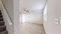 Located at 1003 West Ave in Clearwater, Florida, this two-story residence offers a practical and well-organized layout spread across two floors. Light wood-style flooring runs consistently throughout the home, creating a clean, cohesive aesthetic that brightens each room.

The first floor houses the main living area, kitchen, and entryway. The kitchen is outfitted with white shaker-style cabinetry, granite-look countertops, a double sink, and white appliances including a refrigerator, range, and microwave. A window allows natural light to fill the space. The living room is open and airy, featuring a thermostat and electrical panel conveniently mounted on the wall.

Upstairs, two bedrooms are connected by a hallway and staircase. The primary bedroom is generously sized and includes a ceiling fan with light, a closet, and a window with blinds offering neighborhood views. The second bedroom mirrors this layout with its own ceiling fan, closet, and window. Both rooms feature the same light flooring found throughout the home.

The bathroom includes a full soaking tub and shower combination with brushed gold fixtures and a clean white surround. With five closets distributed across both floors, storage is notably abundant. The home's neutral palette and consistent finishes give it a bright, move-in-ready feel.