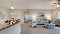 Located at 1000 Worthington Ln in Spring Hill, TN, this thoughtfully designed 3-bedroom, 2-bathroom residence offers comfortable single-floor living. The open-concept living room is spacious and inviting, featuring plush carpeting, a ceiling fan, and a glass door that opens to an outdoor patio, filling the room with natural light and views of the surroundings. Adjacent to the living room, the dedicated dining area is accented by an elegant chandelier, creating an ideal setting for shared meals. The kitchen is well-appointed with rich dark wood cabinetry, ample storage, tile flooring, and black appliances including a range and refrigerator, complemented by a curved breakfast bar that connects seamlessly to the dining space. The generously sized primary bedroom features natural light from large windows and direct access to an en suite bathroom. Two additional carpeted bedrooms offer comfort and flexibility, each with ceiling fans and windows. Both bathrooms are finished with tile flooring, dark wood vanities, and tub-shower combinations. A spacious walk-in closet with wire shelving and hanging storage provides excellent organization. Neutral tones and warm finishes throughout create a cohesive and welcoming ambiance across the entire residence.