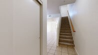 Located in Mesa, Arizona, this two-story, two-bedroom, two-bathroom home offers a functional and well-organized layout across two floors. The main level is the larger of the two floors and features light-filled, open living and dining areas with neutral-toned tile flooring and ceiling fans throughout. The kitchen is efficiently designed with warm wood cabinetry, dark granite-style countertops, black appliances including a refrigerator, range, and built-in microwave, plus a stainless steel sink beneath a window that brings in natural light. A breakfast bar peninsula connects the kitchen to the dining and living space, creating a seamless flow ideal for everyday living. A staircase with a wood handrail and carpeted treads leads to the upper level, where the two bedrooms are situated. The primary bedroom offers a comfortable footprint with plush carpet, a ceiling fan, and a window with vertical blinds. Both bathrooms feature wood-look vinyl flooring, vanities with light-toned cabinetry, and a combination tub/shower. Six closets throughout the home provide generous storage. A patio completes the space, offering outdoor access. The home maintains a clean, neutral palette throughout.