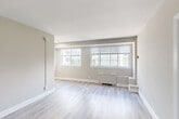 Located in the desirable Chevy Chase neighborhood of Washington, DC, this one-bedroom, one-bathroom residence offers a well-designed layout across a single floor. Light-toned hardwood-style flooring flows throughout the living spaces, complementing the warm neutral walls and crisp white trim that give the home a clean, modern feel.

The combined living and dining area is bright and open, anchored by a bank of multiple windows that allow natural light to pour in and offer views of the surrounding neighborhood. A ceiling fan with a light fixture in the bedroom adds comfort and airflow, while a dedicated closet provides convenient storage.

The kitchen has been thoughtfully updated with white shaker-style cabinetry, quartz countertops, a stainless steel single-basin sink with a brushed nickel faucet, and stainless steel appliances including a gas range and microwave. Marble-look porcelain tile flooring adds an elegant touch underfoot.

The bathroom continues the refined aesthetic with floor-to-ceiling marble-look tile in the glass-enclosed shower, accented by brushed nickel hardware for a polished finish. Two closets provide ample storage throughout the home. The entry area features additional closet access, completing this efficiently arranged and attractively updated residence.