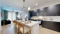 Located at 3712 Stewart Rd in Doraville, GA, this thoughtfully designed 2-bedroom, 4-bathroom residence offers a well-appointed single-level layout. The open-concept kitchen is a standout feature, showcasing floor-to-ceiling navy cabinetry with gold hardware, crisp white quartz countertops, a white subway tile backsplash, stainless steel appliances, and a large center island with seating — ideal for dining and entertaining. Light wood flooring flows throughout the main living areas, enhancing the bright, airy feel.

The living room is characterized by a bold teal accent wall, large windows with natural light, and direct access to an outdoor area through French-style doors, creating a seamless indoor-outdoor connection. A ceiling fan and stylish décor complete the welcoming atmosphere.

The primary bedroom is a comfortable retreat featuring a large window with garden views, plush carpeting, and dedicated closet space. The second bedroom offers a cozy, well-lit space with its own distinct character. The bathrooms are finished with clean white tile surround tubs and modern matte black fixtures. Additional highlights include two closets and a bathroom with convenient laundry access, rounding out a highly functional and stylish living space.