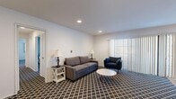 Located at 270 Portofino Way in Redondo Beach, California, this 2-bedroom, 2-bathroom single-story residence offers a thoughtfully organized layout across a comfortable footprint. The living room features recessed lighting, neutral walls, and a bold geometric-patterned carpet that adds visual interest, with vertical blinds along a wide window allowing for adjustable natural light. Adjacent to the living area, the dining room transitions to warm hardwood flooring and is brightened by a large sliding glass door that opens to the outdoors, complemented by a pendant light overhead. The kitchen is well-equipped with dark cabinetry, white countertops, warm hardwood floors, and a full suite of stainless steel appliances including a double wall oven, microwave, dishwasher, and range. The spacious primary bedroom features a calming two-tone wall with a muted sage accent, patterned carpet, and a large window with vertical blinds providing ample natural light. The second bedroom is similarly sized and well-lit. Both bathrooms are finished with light tile flooring and wide vanities featuring generous counter space, undermount sinks, and framed mirrors. A dedicated closet provides additional storage, completing this well-rounded coastal Redondo Beach residence.