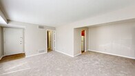 Located at 5303 Rue De Ville in Indianapolis, Indiana, this single-floor, one-bedroom, one-bathroom residence offers a practical and comfortable layout. The living room is the largest area of the home, featuring neutral beige carpeting, warm taupe walls, and two windows that allow natural light to fill the space. A recessed nook with rich cherry-toned cabinetry adds a functional design detail to the room.

The kitchen is equipped with warm honey-toned wood cabinetry featuring decorative raised paneling and ornate hardware, paired with light tile countertops that provide ample workspace. A full-size refrigerator rounds out the functional kitchen layout.

The bedroom offers a comfortable footprint with soft carpeting, a natural light source via a window with blinds, and notable closet storage. Wide louvered bi-fold closet doors span a generous portion of the wall, providing excellent organizational capacity.

The bathroom features a full tub-shower combination with white subway tile surround, chrome fixtures, and classic blue accent tile detailing — a clean, timeless aesthetic. Neutral tones and straightforward finishes carry throughout the home, creating a cohesive and move-in-ready environment ideal for those seeking a manageable, low-maintenance residence in Indianapolis.