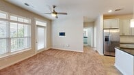 Located at 4212 Napa Oak Dr in Charlotte, NC, this single-floor home offers a well-designed, open-concept layout finished with a neutral color palette and a blend of hardwood-style flooring and plush carpet throughout. The kitchen serves as a central focal point, featuring crisp white shaker cabinetry, dark granite countertops, a large center island with a built-in sink, stainless steel appliances including a range, microwave, dishwasher, and refrigerator, and elegant pendant lighting overhead. Recessed lighting further brightens the space. The kitchen flows seamlessly into the living area, which is appointed with ceiling fans, natural light from large windows with blinds, and direct access via a side entry door. The bedrooms offer comfortable carpeted flooring, generous closet storage — including both walk-in and reach-in configurations — and windows that allow natural light to fill each room. The primary bathroom is equipped with a dual-sink vanity topped with dark granite, white cabinetry, and a walk-in closet accessible directly from the bath. A secondary bathroom features a full tub-shower combo with brushed nickel fixtures and wood-look tile flooring. The overall ambiance is clean, modern, and move-in ready.
