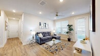Located at 2500 Peaceful River Dr in the charming Mount Dora, Florida community, this single-story 2-bedroom, 2-bathroom home offers a thoughtfully designed layout with modern finishes throughout. Wood-look plank flooring flows seamlessly across the entire home, complementing the bright, neutral palette that creates a clean and welcoming ambiance.

The open-concept living and kitchen area serves as the heart of the home. The living room features recessed lighting, a ceiling fan, and a large window that invites natural light. The kitchen is outfitted with crisp white cabinetry, granite countertops, stainless steel appliances, and a center island with bar seating — ideal for casual dining and entertaining.

A well-lit hallway connects the main living areas to the private quarters. The generously sized primary bedroom includes a ceiling fan and access to a spacious walk-in closet with extensive wire shelving. The second bedroom is equally comfortable with its own ceiling fan and closet. Both bathrooms feature granite-topped vanities and wood-look tile flooring, with one offering a full tub-shower combination.

A dedicated laundry area houses a full-size washer and dryer. The home also includes a patio, a utility room, and three closets, rounding out a practical and comfortable living experience.