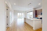 Located at 1557 Logan Street in Denver's vibrant Capitol Hill neighborhood, this thoughtfully designed one-bedroom, one-bathroom residence offers a modern and refined living experience across a single floor. Light-toned hardwood floors flow throughout, creating a cohesive and airy atmosphere that complements the clean white walls and contemporary finishes.

The open-concept kitchen and living area forms the heart of the home. The kitchen is appointed with rich wood cabinetry extending to the ceiling, a striking marble-look quartz backsplash, stainless steel appliances including a gas range and French door refrigerator, and a generous waterfall-edge island with an integrated sink — ideal for both cooking and entertaining. Sleek pendant lighting adds a warm, modern touch overhead.

The living area is bright and spacious, benefiting from tall ceilings and floor-to-ceiling sliding glass doors that open to a private balcony with sweeping city views of the Denver skyline.

The bedroom is well-proportioned, featuring large windows that invite natural light and a barn-style sliding door leading to a walk-in closet.

The bathroom offers a spa-like retreat with warm wood vanity cabinetry, large-format tile flooring, and a glass-enclosed walk-in shower adorned with elegant herringbone tile. A hallway connects the spaces with ease, completing this polished and functional home.