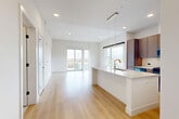 Located at 1557 Logan Street in Denver's vibrant Capitol Hill neighborhood, this thoughtfully designed one-bedroom, one-bathroom residence offers a modern and refined living experience across a single floor. Light-toned hardwood floors flow throughout, creating a cohesive and airy atmosphere that complements the clean white walls and contemporary finishes.

The open-concept kitchen and living area forms the heart of the home. The kitchen is appointed with rich wood cabinetry extending to the ceiling, a striking marble-look quartz backsplash, stainless steel appliances including a gas range and French door refrigerator, and a generous waterfall-edge island with an integrated sink — ideal for both cooking and entertaining. Sleek pendant lighting adds a warm, modern touch overhead.

The living area is bright and spacious, benefiting from tall ceilings and floor-to-ceiling sliding glass doors that open to a private balcony with sweeping city views of the Denver skyline.

The bedroom is well-proportioned, featuring large windows that invite natural light and a barn-style sliding door leading to a walk-in closet.

The bathroom offers a spa-like retreat with warm wood vanity cabinetry, large-format tile flooring, and a glass-enclosed walk-in shower adorned with elegant herringbone tile. A hallway connects the spaces with ease, completing this polished and functional home.