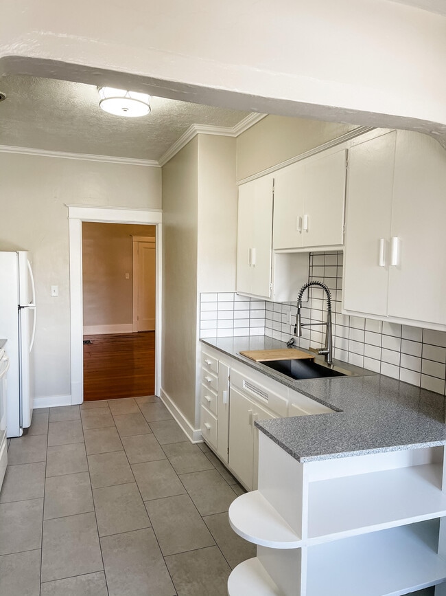 Cocina con fregadero grande y salpicadero de azulejos. - 6 Nineteen Apartments