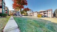 Located at 2828 Egypt Rd in Norristown, Pennsylvania, this residential complex offers a well-maintained, multi-building community set against a backdrop of mature trees and open green spaces. The buildings feature classic brick exteriors accented by green shutters, teal structural columns, and distinctive burgundy awnings over entryways, creating a cohesive and visually appealing aesthetic throughout the property.

Each building rises across multiple levels, with private balconies fitted with wrought iron railings accessible from upper-floor units. Ground-level units benefit from direct access to the surrounding landscaped grounds. Concrete walkways connect the buildings, providing convenient pedestrian pathways across the property's expansive lawn areas.

The grounds are generously landscaped with neatly trimmed shrubbery along building facades, open grassy courtyards, and an impressive canopy of mature deciduous trees that provide seasonal color and shade. Dedicated parking areas with clearly marked spaces are conveniently situated throughout the complex, ensuring easy access for residents.

The overall ambiance of the community is that of a peaceful, well-established residential setting, with open sight lines across the grounds offering views of the surrounding tree-lined landscape. The property's classic architectural character, combined with its well-kept outdoor spaces, reflects a commitment to maintaining a comfortable and attractive community environment.