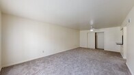 Located at 200 S Main St in Ellenville, NY, this single-floor residence offers a clean, functional layout across several well-proportioned rooms. The living area is generously sized, featuring plush wall-to-wall carpeting, neutral cream-toned walls, and a ceiling fan that adds both comfort and airflow. Large windows allow abundant natural light to fill the space, offering views of surrounding greenery.

The bedrooms are carpeted and feature sliding closet doors with built-in rods for ample storage. One bedroom includes a ceiling fan, while both rooms benefit from natural light through windows. The layout connects seamlessly to the bathrooms, which are fitted with light wood-look vinyl plank flooring, providing a clean and modern contrast to the softer tones elsewhere in the unit.

The kitchen is practical and well-equipped, featuring warm honey-toned wood cabinetry, dark countertops, a stainless steel sink, and white appliances including a range and refrigerator. The kitchen flooring mirrors the light vinyl plank found in the bathrooms, maintaining visual consistency throughout the wet areas.

Overall, the space presents a straightforward, comfortable layout with consistent finishes, neutral tones, and practical storage throughout, making it a functional and move-in-ready residence in the heart of Ellenville, New York.