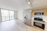 Located at 8175 NW 107th Ave in Doral, FL, this thoughtfully designed one-bedroom, one-bathroom residence offers a clean, contemporary aesthetic across a single floor. Light wood-tone flooring runs throughout, complementing the crisp white walls and modern finishes that define the space.

The open-concept living and dining area flows seamlessly from the kitchen, creating an inviting and functional layout. Floor-to-ceiling sliding glass doors lead to a private balcony, filling the living area with abundant natural light and offering outdoor views. The kitchen is well-appointed with warm wood cabinetry, white lower cabinets, light quartz countertops, and a full suite of stainless steel appliances including a French door refrigerator, electric range, built-in microwave, and dishwasher. Track lighting overhead adds a modern touch.

The bedroom is a bright, serene retreat with a large window that brings in natural light, neutral walls, and direct access to a dedicated closet. A utility area houses a stacked in-unit washer and dryer for added convenience.

The bathroom features a clean, minimalist design with a white vanity, undermount sink, large-format tile walls, and a glass-enclosed walk-in shower. Every detail of this residence reflects a modern, move-in-ready standard ideal for comfortable urban living in Doral.