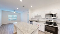 Located at 2707 Pointe North Blvd in Albany, Georgia, this well-appointed 2-bedroom, 3-bathroom residence offers a thoughtfully designed single-floor layout with modern finishes throughout. The heart of the home is an open-concept kitchen featuring crisp white shaker cabinets, a classic subway tile backsplash, granite countertops, and a full suite of stainless steel appliances including a refrigerator, range, microwave, and dishwasher. A central granite-topped island provides additional prep and dining space, flowing seamlessly into the living area, which is enhanced by recessed lighting and a ceiling fan. Light wood-style flooring runs throughout the main living areas, adding warmth and continuity. Each bedroom is finished with plush carpet, a ceiling fan, and generous natural light from wide windows with blinds. The primary bedroom connects to an en-suite bathroom complete with a granite vanity and access to a spacious walk-in closet with wire shelving. Additional bathrooms feature clean white finishes and tub-shower combinations. Two dedicated closets throughout the home ensure ample storage. The overall aesthetic is bright, clean, and contemporary, making this an efficient and comfortable living space.