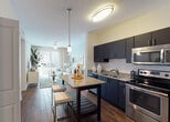 Located at 2263 S Douglas Rd in Miami, FL, this single-floor residence showcases a thoughtfully designed open-concept layout that seamlessly connects the kitchen, dining, and living areas. The kitchen is a standout feature, outfitted with dark espresso cabinetry, granite countertops, stainless steel appliances — including a refrigerator, electric range with over-the-range microwave, and dishwasher — complemented by a white subway tile backsplash and a central island with bar seating. Wood-look tile flooring flows through the main living areas, adding warmth and cohesion to the space. The living room is bright and welcoming, highlighted by soft blue accent walls, a ceiling fan, sliding glass doors that invite natural light, and access to an outdoor area. The bedrooms are carpeted and serene, featuring the same cool blue palette and ample natural light from horizontal-blind windows. The bathroom is well-appointed with dark cabinetry, granite vanity countertops, large-format floor tiles, and a full tub-shower combination. Throughout the residence, framed black-and-white photography adds a curated, urban aesthetic, tying together a clean and contemporary Miami-inspired design.