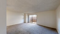 Located at 4255 S Tamarus St in Las Vegas, NV, this single-story residence offers a functional 2-bedroom, 2-bathroom layout designed for comfortable everyday living. The open living room is carpeted and features a textured ceiling, neutral walls, and a sliding glass door that leads to a private outdoor patio, allowing natural light to fill the space. The kitchen is equipped with warm wood-toned cabinetry, light quartz-style countertops, and white appliances, and opens to a dining area with light wood-look flooring and a ceiling fan overhead. Both bedrooms are carpeted and finished with the same neutral palette and textured ceilings, each offering closet storage and easy access to the hallway. The two bathrooms are cleanly appointed with white vanity cabinetry, light countertops, large mirrors, and modern fixtures. Two dedicated closets provide additional storage throughout the unit. The overall design is straightforward and move-in ready, with consistent finishes across all rooms that create a cohesive, understated aesthetic well-suited to the Las Vegas climate and lifestyle.