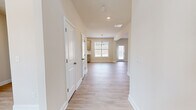 This two-story home offers a thoughtfully organized layout across two floors, with the main level hosting the primary living and kitchen areas, and the upper floor dedicated largely to sleeping quarters. The open-concept main level features light hardwood-style flooring throughout, neutral warm-toned walls, and recessed lighting that keeps the space feeling bright and airy. A chandelier anchors the dining area, while multiple windows invite natural light into the combined kitchen and living space. The kitchen is equipped with gray shaker-style cabinetry, granite countertops, a stainless steel sink, subway tile backsplash, and stainless steel appliances. A separate living room and direct exterior door access add to the functionality of the ground floor, which also includes an attached garage with a built-in electrical panel. Upstairs, four generously sized bedrooms feature plush carpeting and ample closet space, including walk-in closets with wire shelving systems and natural light from windows. The four bathrooms are finished with granite-topped vanities and full tub-shower combinations. A dedicated laundry room with washer/dryer hookups and overhead wire shelving adds everyday convenience. The home presents a clean, modern aesthetic throughout.