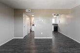 Located at 1021 W B St in Ontario, California, this single-floor unit offers a practical and functional layout with consistent wood-look flooring throughout. The open living area is bright and spacious, featuring neutral-toned walls with warm yellow accents, textured ceilings, and a large window that invites ample natural light and views of the surrounding neighborhood. A louvered closet door provides convenient storage access directly from the living space. The kitchen is efficiently designed in an L-shaped configuration, equipped with white cabinetry, dark granite countertops, a full suite of black appliances including a range, built-in microwave, and dishwasher, along with a window above the sink that brings in additional natural light. A ceiling fan overhead ensures comfortable airflow. The bathroom features a granite-topped vanity with an undermount sink, a large mirror, and a walk-in shower with chrome fixtures. The overall layout is compact yet well-organized, offering a straightforward flow between the living, kitchen, and bathroom areas. The unit's clean finishes and practical design make it a functional living space in the heart of Ontario, CA.