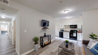 Located at 1000 Diamond St in Philadelphia's vibrant North Philadelphia neighborhood, this four-bedroom, two-bathroom unit offers a well-organized single-floor layout designed for comfortable shared living. The open-concept living and kitchen area forms the heart of the home, featuring light wood-style flooring, neutral walls, and seamless flow between spaces. The kitchen is equipped with white cabinetry, granite-style countertops, a stainless steel sink, and black appliances including a range, dishwasher, and over-the-range microwave. The living room provides a welcoming gathering space with room for seating and a wall-mounted TV setup. Each of the four bedrooms offers a cozy, private retreat with carpet flooring and windows that bring in natural light. One bedroom features direct access to a bathroom, offering added convenience. The two bathrooms are clean and modern, each featuring white vanities, tile flooring, and backlit mirrors; one includes a tub-shower combination. Additional spaces include a hallway, closet, utility room, and a balcony for outdoor access. The unit is ideally situated near Temple University, making it well-suited for students or young professionals seeking a functional and comfortable home in Philadelphia.
