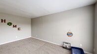 Located at 2500 E James Ave in Baytown, TX, this single-floor, 2-bedroom, 2-bathroom home offers a practical and comfortable layout. The living area is generously sized, featuring neutral-toned carpet, soft gray walls, and a large window that fills the space with natural light. The galley-style kitchen is well-appointed with white cabinetry, dark countertops, wood-look flooring, and black appliances, including a gas range and refrigerator. In-unit laundry is conveniently accommodated within the kitchen area. Both bedrooms are carpeted and feature ceiling fans with light fixtures and windows with blinds that allow for natural light and outdoor views. The spacious primary bedroom includes a walk-in closet outfitted with built-in shelving, hanging rods, and additional shelf units for ample storage. Each bathroom includes a tub-shower combination with clean white tile surrounds. A hallway connects the main living areas to the bedrooms and bathrooms, maintaining an efficient flow throughout. The home's neutral color palette and consistent finishes create a cohesive and move-in-ready atmosphere throughout.