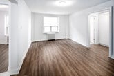 Located on the fifth floor of 262 Jarvis Street in downtown Toronto, this one-bedroom, one-bathroom unit offers a practical and efficiently designed layout across a single floor. The space is finished with warm hardwood-style flooring throughout the main living areas, contributing to a cohesive and clean aesthetic.

The entrance leads into a central hallway equipped with a sliding-door closet, providing convenient storage. The living room is a well-proportioned open area with white walls and a window that brings in natural light, complemented by a traditional radiator. The bedroom, though compact, includes its own window with an exterior view and a radiator, maintaining a bright and functional character.

The kitchen features white shaker-style cabinetry, taupe countertops, a stainless steel sink with a modern faucet, a gas range, and white tile backsplash. Marble-style flooring adds a polished touch to this space. The bathroom continues the refined detailing with marble-style tile flooring, a tiled shower-tub combination, a window for ventilation and natural light, and a mirrored medicine cabinet. The overall ambiance of the unit is clean, neutral, and move-in ready.