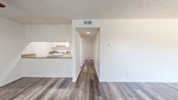 Located at 20600 Seine Avenue in Lakewood, CA, this single-story, 3-bedroom, 1-bathroom home offers a functional and well-organized layout across one floor. The interior is finished with wood-look vinyl plank flooring throughout the main living areas, complemented by textured ceilings and crisp white walls that create a clean, bright atmosphere.

The living room provides a comfortable open area that flows into a hallway connecting the rest of the home. The galley-style kitchen features white cabinetry, granite-look countertops, a gas range, and a double-basin sink — offering an efficient cooking space with ample storage. A pass-through opening connects the kitchen to the living area.

The three bedrooms vary in finish and size. The primary bedroom includes a ceiling fan with light fixture and wood-look flooring, while the two additional bedrooms feature plush carpeting and windows with vertical blinds that bring in natural light and outdoor views of surrounding greenery. Each bedroom benefits from its own dedicated closet.

The full bathroom is neatly appointed with a white vanity with granite-look countertop, a combination tub and shower, and wood-look flooring. A central hallway connects all rooms, providing a logical and efficient flow throughout the home. Three closets total offer practical storage throughout the space.