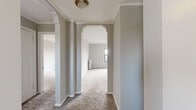 Situated at 6104 S Woodlawn Ave in Chicago's historic Hyde Park neighborhood, this single-floor unit blends classic architectural character with functional living spaces. The layout is defined by elegant arched doorways with decorative molding detailing, adding a timeless design element that connects the carpeted living and bedroom areas seamlessly.

The living spaces are finished with neutral-toned wall-to-wall carpeting, soft gray walls, and crown molding throughout. Ceiling fans are installed in the main rooms, ensuring year-round comfort alongside the classic cast-iron radiators that provide radiant heat. Natural light filters in through multiple windows, several of which offer open views of the surrounding Chicago cityscape.

The kitchen is efficiently designed with white cabinetry offering ample storage, dark laminate countertops, a gas range, a full-size refrigerator, and a stainless steel sink. Light ceramic tile flooring completes the kitchen, and a large window brings in natural light while framing urban views of the city.

The bedrooms are generously proportioned, each featuring carpeted floors, ceiling fans with light fixtures, and windows that invite in natural light and city views. Additional radiator units in the rooms ensure consistent warmth throughout the colder Chicago months. The overall ambiance of the space is clean, bright, and move-in ready.