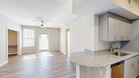 Located at 5222 Shadydell Dr in Fort Worth, TX, this well-appointed one-bedroom, one-bathroom residence offers a thoughtfully designed single-floor layout. The open-concept kitchen and living area serves as the heart of the home, highlighted by granite countertops, gray shaker-style cabinetry, stainless steel appliances, and a peninsula that flows naturally into the living space. Light wood-look flooring runs throughout the main areas, complemented by a ceiling fan and abundant natural light streaming through multiple windows and a glass door leading to a private balcony. The kitchen features a galley-style configuration with ample upper and lower cabinetry, a stainless sink, and a dedicated dining or office nook with a built-in granite-topped desk. The carpeted bedroom is generously sized, offering ceiling fan, a large window with natural light, and access to a dedicated closet. Additional closets throughout provide plentiful storage. The bathroom includes a full tub/shower combo with tiled surround, granite vanity countertop, and wood-look flooring. A dedicated laundry room with in-unit washer hookup adds everyday convenience. Neutral warm-beige tones throughout create a clean, cohesive, and inviting ambiance.