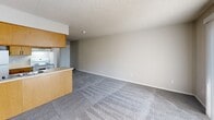 Located at 513 E. Marion Rd in Wichita, Kansas, this one-bedroom, one-bathroom unit offers a practical and well-organized single-floor layout. The galley-style kitchen is efficiently designed with warm oak cabinetry lining both walls, laminate countertops, a double-basin sink, and white appliances including a range and refrigerator. Light wood-style flooring runs throughout the kitchen, giving it a clean, easy-to-maintain surface. Adjacent to the kitchen, the open living area features neutral-toned carpet and a textured ceiling, providing a blank canvas for a variety of furniture arrangements. The bedroom is a comfortable size, finished with plush carpet, a window that brings in natural light, and notably features two closets — a standard reach-in and an additional open closet — offering generous storage. The full bathroom is neatly appointed with warm oak vanity cabinetry, overhead storage, tile flooring in an earthy tone, and a full tub and shower combination. Throughout the unit, neutral wall colors, textured ceilings, and consistent finishes create a cohesive and functional living environment suited for everyday comfort.