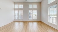 Located at 215 Florida St in Knoxville, TN, this thoughtfully designed 2-bedroom, 2-bathroom residence offers a bright, contemporary living experience across a generous single-floor layout. Soaring ceilings and oversized windows with transom panels flood the open-concept kitchen and living area with abundant natural light, creating an airy, expansive feel. The kitchen is well-appointed with white shaker cabinetry, quartz countertops, a large center island, stainless steel appliances including a refrigerator, range, microwave, and dishwasher, and elegant pendant lighting. The living area opens directly to a private balcony with outdoor views. Light-toned hardwood-style flooring flows consistently throughout the entire residence. Both bedrooms are generously proportioned with high ceilings, large windows, and double-door closets. The primary bathroom features a glass-enclosed walk-in shower, a white vanity with quartz countertops, and a large mirror, while the second bathroom offers a full soaking tub and shower combination with matching finishes. Additional conveniences include a dedicated laundry area, three closets for ample storage, and a welcoming entrance. The clean, neutral palette and modern fixtures throughout give the space a fresh, move-in-ready appeal.