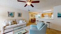 This single-floor, 2-bedroom, 2-bathroom residence offers a practical and comfortable layout designed for everyday living. The living room serves as the heart of the home, featuring plush carpeting, a ceiling fan with integrated lighting, and a large window dressed with elegant drapes that allow generous natural light to fill the space. The room flows seamlessly into the dining area, which is anchored by a chandelier overhead and a sliding glass door that opens onto a private balcony overlooking greenery outside.

The galley-style kitchen is outfitted with warm wood cabinetry, a coil-burner range, dishwasher, and double-basin sink, complemented by hardwood-style flooring and a dedicated pantry closet for additional storage.

The two bedrooms are carpeted and comfortably sized, each featuring windows with blinds and curtain panels that provide natural light and privacy. Both offer closet storage and share access to the two bathrooms, one of which includes hardwood-style flooring, a single vanity with a wide mirror, and a shower-tub combination. Throughout the residence, textured ceilings and neutral wall tones create a cohesive, understated aesthetic.