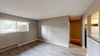 Located at 916 Cypress Point Dr in Crown Point, Indiana, this single-floor unit offers a clean, functional layout with consistent design choices throughout. The living areas feature light-toned vinyl plank flooring that extends seamlessly across multiple rooms, complemented by neutral gray wall tones and crisp white trim and baseboards that create a cohesive, modern aesthetic.

The main living spaces are well-proportioned and filled with natural light courtesy of multiple windows that frame outdoor views of the surrounding neighborhood. Baseboard heating units are present in several rooms, ensuring efficient warmth throughout the colder months, while a wall-mounted air conditioning unit provides cooling comfort in one of the primary rooms.

The kitchen is equipped with white cabinetry featuring wood-trimmed accents, dark granite-style countertops, and white appliances including a range, dishwasher, and refrigerator. Light vinyl flooring ties the kitchen into the overall design of the unit, and ample upper and lower cabinet storage makes it a highly practical space.

The bathroom features a gray vanity with a speckled stone-look countertop, an undermount sink with brushed nickel fixtures, and a lighted mirror above, creating a tidy and well-appointed space. The overall ambiance of the unit is bright, neutral, and move-in ready, offering a straightforward and comfortable living environment.