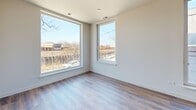 Located in Chicago's Ravenswood neighborhood, this single-floor unit offers a thoughtfully designed layout that maximizes its compact footprint. The open-concept kitchen and living area serves as the heart of the unit, featuring warm hardwood-style flooring throughout and a clean, contemporary aesthetic defined by neutral tones and crisp white walls.

The kitchen is well-appointed with taupe flat-front cabinetry extending to the ceiling, stainless steel appliances including a gas range, microwave, dishwasher, and refrigerator, complemented by a tiled backsplash and a white quartz-topped island with an integrated sink. A stacked in-unit washer and dryer is conveniently housed within the kitchen area.

Large corner windows in the living area flood the space with natural light and offer views of the surrounding neighborhood. The bedroom features a wide double sliding-door closet with built-in shelving and a dedicated window. The bathroom is finished with large-format stone-look tile flooring, a white vanity with quartz countertop, a framed mirror, and a glass-enclosed walk-in shower, creating a clean, modern feel throughout.