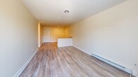 This 530 square foot apartment in Seabrook, NH, offers a thoughtfully designed living space on a single floor. The property features a spacious 140 square foot primary bedroom, complemented by a well-appointed bathroom. The open-concept layout maximizes the available space, seamlessly integrating the living room and kitchen areas.

Throughout the apartment, modern finishes create a fresh and inviting atmosphere. The rooms boast sleek vinyl plank flooring, reminiscent of hardwood, which adds warmth and durability to the space. Neutral-toned walls provide a versatile backdrop for various decor styles.

The living area is enhanced by a ceiling fan with an integrated light fixture, ensuring comfort and proper air circulation. Large windows and glass doors allow ample natural light to flood the space, creating a bright and airy ambiance. An air conditioning unit is strategically placed to maintain a comfortable temperature year-round.

The bathroom showcases a contemporary design with clean white subway tiles, a bathtub-shower combination, and modern black fixtures. The kitchen, while compact, offers essential amenities and storage solutions.

This efficiently designed apartment combines functionality with style, making it an ideal residence for individuals or couples seeking a cozy yet modern living space in Seabrook, NH.