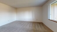 Located in Vancouver, Washington, this one-bedroom, one-bathroom unit offers a practical and well-organized single-floor layout. The entrance opens into a space that transitions between hard-surface flooring and plush carpeting throughout the common and private areas. The galley-style kitchen is efficiently designed with warm wood cabinetry lining both walls, gray laminate countertops, a double-basin sink, and white appliances including a range and refrigerator. Light wood-look flooring runs underfoot, adding warmth to the space. The living room provides a comfortable, open area with carpet flooring, a textured ceiling, and a glazed entry door that allows natural light to filter in. The bedroom is a well-proportioned retreat featuring carpet flooring, a window with a neighborhood view, and two closets with wood-tone doors offering generous storage. A third closet is accessible from the hallway, adding further utility. The full bathroom includes a shower-tub combination and is finished with light, clean materials. Textured ceilings are consistent throughout the unit, contributing to a cohesive aesthetic. With three closets, dedicated rooms for every function, and a straightforward layout, this unit in Vancouver's 98682 zip code offers efficient, comfortable everyday living.