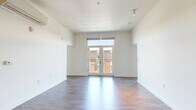 Located in Sacramento's vibrant R Street Corridor, this 2-bedroom, 2-bathroom unit offers a well-designed single-floor layout with a clean, contemporary aesthetic throughout. Wood-style plank flooring flows seamlessly across the open living, dining, and kitchen areas, creating a cohesive and modern feel. The living room is bright and airy, highlighted by French doors that invite natural light and provide access to an outdoor view. A wall-mounted mini-split system ensures year-round comfort. The kitchen is thoughtfully outfitted with white cabinetry extending to the ceiling, a stainless steel range with a sleek overhead hood, a dishwasher, refrigerator, and an adjacent open shelving area that doubles as a pantry. Both bedrooms feature wood-style flooring, individual climate control units, and closets with built-in hanging rods. The two bathrooms are finished with wood-look tile flooring, floating white vanities, large mirrors with overhead lighting, and full bathtub-shower combinations. Additional conveniences include in-unit laundry and ample closet storage. The unit's neutral white walls and consistent modern finishes give the space a bright, clean ambiance throughout.
