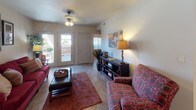 This single-floor residence offers a practical and inviting layout designed for comfortable everyday living. The living room serves as the heart of the home, featuring tile flooring, a ceiling fan with light fixture, and a bright entry with double front doors that allow natural light to pour in. The space accommodates a relaxed seating arrangement and opens into the adjacent dining nook, which is lit by an elegant chandelier and framed by a large window with blinds, creating a welcoming atmosphere for meals and gatherings.

The galley-style kitchen is efficiently designed with dark cabinetry lining both sides, granite-style countertops, tile flooring, and white appliances including an electric range, refrigerator, and dishwasher. A doorway from the kitchen leads directly into a dedicated laundry area with a full-size washer and dryer, adding everyday convenience.

The bedroom is a comfortable retreat featuring tile flooring, a ceiling fan, a window that brings in natural light, and a mirrored closet that enhances the sense of space. The full bathroom is clean and functional, finished with white tile surrounds accented by diamond-shaped inlays, a tub-shower combination, tile flooring, and a vanity with ample counter space.
