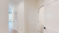 Located at 445 51st St in Wilmington, NC, this thoughtfully designed 2-bedroom, 2-bathroom residence offers a clean, modern aesthetic throughout its single-floor layout. The open-concept kitchen and living area serves as the heart of the home, featuring light hardwood-style flooring, white shaker cabinetry, a striking navy blue island with a light stone countertop, pendant lighting with brass accents, subway tile backsplash, and stainless steel appliances. Large windows flood the living space with natural light, while a built-in shelving nook adds functional character. The primary bedroom is generously sized, complete with a ceiling fan, wide windows with outdoor views, and a spacious walk-in closet with built-in wire shelving. The primary bathroom is well-appointed with a dual-sink granite vanity, matte black hardware, a glass-enclosed walk-in shower with vertical white tile, and wood-look flooring. The second bedroom features plush carpet and a window for natural light. The second bathroom includes a tub-shower combo, granite vanity, and matching matte black fixtures. Clean white walls, two-panel interior doors, and consistent matte black hardware accents create a cohesive, contemporary feel throughout.