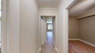 Located on the third floor at 1220 Boren Ave in the heart of Seattle, WA, this two-bedroom, one-bathroom apartment offers a practical and well-organized single-level layout. Light wood laminate flooring flows throughout the living areas and bedrooms, lending a clean, cohesive aesthetic to the space.

The spacious primary bedroom features crown molding, a large window that invites natural light and city views, and a classic radiator for warmth. A built-in closet area provides dedicated storage. The second bedroom includes a ceiling fan with light fixture and an open closet with a wood shelf, while neutral warm-toned walls keep the room versatile.

The galley-style kitchen is efficiently designed with white cabinetry lining both walls, offering ample upper and lower storage. It is equipped with an electric range, refrigerator, dishwasher, and a stainless sink — all complemented by tile backsplash and light tile flooring. Notably, an in-unit washer is tucked conveniently at the end of the kitchen.

The bathroom is finished with full white subway tile surrounding the tub-shower combination, paired with a pedestal sink and mirror. Crown molding throughout the living areas adds a refined architectural touch, while the overall neutral palette creates a bright, move-in-ready atmosphere.