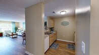 Located at 4211 Fox Rd in Raleigh, NC, this single-floor residence offers a well-organized layout designed for comfortable everyday living. The open-concept living and dining area serves as the heart of the home, featuring durable wood-look flooring, neutral warm-toned walls, and generous natural light streaming through large windows dressed with teal grommet curtains. The living room provides ample space for seating and entertainment, with direct access to an outdoor area via a glass door.

Adjacent to the living space, the dining area comfortably accommodates a round dining table and chairs, flowing seamlessly into the kitchen. The kitchen is equipped with light wood cabinetry, granite-style countertops, white appliances including a coil electric range, over-the-range microwave, dishwasher, and refrigerator, all accented by wood-look flooring.

The bedrooms feature plush carpeting, ceiling fans, and windows that invite natural light. The primary bedroom includes a walk-in closet, while warm accent walls lend a cozy atmosphere to both rooms. The bathroom continues the wood-look flooring theme and is outfitted with a shower-tub combination. Throughout the home, a textured ceiling and consistent neutral palette create a cohesive, welcoming ambiance.
