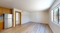 Located at 201 W Blacklidge Dr in Tucson, Arizona, this one-bedroom, one-bathroom unit offers a thoughtfully updated interior within a cozy, efficiently designed footprint. The open layout connects the living area and kitchen, maximizing usability throughout the space. Light wood-style luxury vinyl flooring runs throughout, providing a clean, cohesive look that brightens every room.

The living area is open and unencumbered, with white shiplap-style wall paneling that adds a modern farmhouse character. The kitchen features warm wood-toned cabinetry paired with white appliances, including a refrigerator, creating a functional contrast against the light walls and flooring.

The bedroom is a comfortable size, featuring the same shiplap-style paneling, a textured ceiling, and a multi-pane window that invites natural light and outdoor views of the surrounding greenery. An additional window in the space further enhances brightness throughout the unit.

The bathroom is clean and well-appointed, with warm wood-toned vanity cabinetry, a round mirror, a toilet, and a full shower-tub combination with built-in shelving and a sliding rod. Light wood flooring continues into the bathroom, maintaining visual consistency. A wall sconce near the entry provides warm accent lighting. This unit is ideal for those seeking a freshly updated, low-maintenance residence in Tucson.