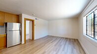 Located at 201 W Blacklidge Dr in Tucson, Arizona, this one-bedroom, one-bathroom unit offers a thoughtfully updated interior within a cozy, efficiently designed footprint. The open layout connects the living area and kitchen, maximizing usability throughout the space. Light wood-style luxury vinyl flooring runs throughout, providing a clean, cohesive look that brightens every room.

The living area is open and unencumbered, with white shiplap-style wall paneling that adds a modern farmhouse character. The kitchen features warm wood-toned cabinetry paired with white appliances, including a refrigerator, creating a functional contrast against the light walls and flooring.

The bedroom is a comfortable size, featuring the same shiplap-style paneling, a textured ceiling, and a multi-pane window that invites natural light and outdoor views of the surrounding greenery. An additional window in the space further enhances brightness throughout the unit.

The bathroom is clean and well-appointed, with warm wood-toned vanity cabinetry, a round mirror, a toilet, and a full shower-tub combination with built-in shelving and a sliding rod. Light wood flooring continues into the bathroom, maintaining visual consistency. A wall sconce near the entry provides warm accent lighting. This unit is ideal for those seeking a freshly updated, low-maintenance residence in Tucson.