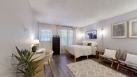 Located at 5095 E Donald Ave in Denver, CO, this thoughtfully laid-out unit offers a practical and comfortable living experience across a single floor. The spacious bedroom serves as the centerpiece of the home, featuring warm wood-look flooring, a textured ceiling, and multiple windows dressed with blinds and curtains that allow generous natural light to filter in. The room comfortably accommodates a full sleeping area alongside a dedicated workspace, making it well-suited for both rest and productivity.

The kitchen is efficiently designed with white cabinetry, granite-style countertops, a classic subway tile backsplash, a stainless steel sink, and black appliances including a dishwasher and electric range. A breakfast bar with seating connects the kitchen to the main living area, enhancing the open feel of the space.

Two bathrooms provide added convenience, each featuring wood-look flooring and clean, neutral finishes. One bathroom includes a tub-shower combination. A dedicated closet with a full-width hanging rod offers practical storage. The hallway connecting all rooms flows naturally, giving the unit a cohesive and organized layout. Throughout, neutral gray walls and consistent flooring create a calm, unified aesthetic ideal for comfortable everyday living.