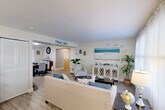 Located at 596 Bullocks Point Ave in East Providence, Rhode Island, this two-story home offers a well-designed layout spread across two floors of comfortable living space. The main floor features an open and inviting living room with light wood-style flooring, large windows that bring in natural light, and a relaxed coastal aesthetic accented by soft blues and neutral tones. The living area flows seamlessly into the dining room, which provides a dedicated space for entertaining. The updated kitchen stands out with crisp white shaker cabinetry, dark granite countertops, stainless steel appliances including a gas range and built-in microwave, and a window that adds natural brightness to the workspace. Upstairs, the two bedrooms offer comfortable retreats, each with ceiling fans, light wood-style flooring, and generous closet space — five closets are distributed throughout the home. The primary bedroom is a well-proportioned space with a ceiling fan and easy access to storage. The second bedroom also features a ceiling fan and a bright window. The full bathroom includes a tub-shower combination with tiled surround. Additional functional spaces include an office, a utility room, and a hallway, completing this well-rounded and move-in-ready home.