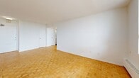 Located at 30 High St E, Suite 605 in Mississauga, Ontario, this one-bedroom, one-bathroom unit offers a well-organized layout across a single floor. Warm parquet flooring flows throughout the living areas and bedroom, lending the space a classic character that pairs well with the clean white walls and bright, open feel.

The living room is generously proportioned, bathed in natural light from large windows that frame views of the surrounding Mississauga cityscape. A baseboard heating system runs along the windowed wall, ensuring year-round comfort. The space provides a welcoming and functional area for everyday living.

The kitchen has been thoughtfully renovated with white shaker-style cabinetry, dark countertops, a white subway tile backsplash, and stainless steel appliances including a range with microwave hood and refrigerator. Large-format white tile flooring completes the clean, modern aesthetic.

The bedroom is a comfortable size, featuring the same warm parquet flooring, crisp white walls, and a sliding-door closet that offers practical storage. The room connects easily to the rest of the unit via a central hallway.

The bathroom is finished with floor-to-ceiling white subway tile surrounding a soaker tub and shower combination with chrome fixtures, creating a clean and timeless look throughout.