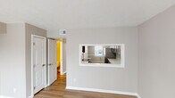 Located at 738 Lake Nora N Ct in Indianapolis, Indiana, this two-floor home offers a clean, neutral aesthetic throughout, with thoughtfully updated finishes that create a welcoming and functional living environment.

The main living area features light wood-look flooring and large sliding glass doors fitted with vertical blinds, allowing generous natural light to fill the space. An adjacent room with similar flooring provides flexible living or dining space. A pass-through window connects the living area to the kitchen, enhancing the open feel between rooms.

The kitchen is well-appointed with dark gray shaker-style cabinetry, bright white countertops, and stainless steel appliances including a refrigerator and dishwasher. A single-basin sink is positioned beneath a window, and light wood-look flooring ties the space together with the rest of the main level.

The bedrooms are carpeted in a neutral tone and feature natural light from windows with blinds. Ample closet space is provided, including a large bi-fold closet. The textured ceilings are consistent throughout the home.

The bathroom includes a full tub-shower combination with white tile surround, a toilet, and a vanity, all finished in a clean, neutral palette. The overall ambiance of the home is bright, understated, and move-in ready.