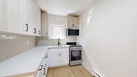 Located at 1214 Avenue Rd, Unit 2 in Toronto's desirable Avenue Road corridor, this thoughtfully designed one-bedroom unit blends classic architectural character with contemporary updates. Light-toned hardwood flooring flows throughout, creating a warm and cohesive aesthetic across the entire space.

The unit features two distinct living areas. The front living room is a standout, boasting a beautifully detailed ornamental fireplace, a wall-mounted split-system air conditioner, and recessed lighting. A graceful arched doorway connects it to the second living area, which is bathed in natural light from a large bay window overlooking the street, framed by a classic cast-iron radiator below.

The kitchen is efficiently laid out with white shaker-style lower cabinets, light wood upper cabinetry with matte black hardware, clean white countertops, a stainless steel range, built-in microwave, and a stainless steel refrigerator — all finished with light hardwood flooring and a window for natural ventilation.

The spacious primary bedroom offers a bright window, a cast-iron radiator, a wall-mounted air conditioning unit, and access to a dedicated closet. A private outdoor deck provides additional outdoor space with views of the surrounding neighbourhood. The overall ambiance is clean, bright, and move-in ready.