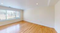 Located at 20 Thornton Road in Brookline, MA, this two-bedroom, two-bathroom residence is thoughtfully arranged across two floors. The lower level houses the kitchen and living area, while the upper floor accommodates both bedrooms and additional living space.

The kitchen is well-appointed with warm honey-toned cabinetry, dark granite countertops, and a full suite of stainless steel appliances, including a gas range, built-in microwave, and French door refrigerator. A granite-topped island with an integrated sink adds functional counter space and a polished focal point to the room.

Both bedrooms feature gleaming hardwood floors, crown molding, and windows that admit generous natural light with views of the surrounding neighborhood. The spacious primary bedroom includes a built-in closet with shelving and drawers, offering practical storage solutions. The second bedroom is similarly bright and well-proportioned.

The bathrooms are finished with clean white subway tile, a tub-shower combination, and a marble-topped vanity with brushed gold fixtures. Consistent hardwood flooring, neutral walls, and recessed lighting throughout create a cohesive, understated aesthetic across the residence.