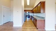 This thoughtfully designed 2-bedroom residence in Midvale, Utah, offers a comfortable and functional single-floor layout. The open-concept living and kitchen area serves as the heart of the home, bathed in natural light from multiple windows with slatted blinds. The living room features warm hardwood-style flooring, a ceiling fan with a decorative light fixture, and a classic white-mantled fireplace that adds a cozy focal point. Direct exterior access through a glass-panel door enhances the bright, airy feel of the space.

The kitchen is well-equipped with rich wood cabinetry, granite countertops, and a full suite of stainless steel appliances, including a refrigerator, range, microwave, and dishwasher. Vaulted ceiling details above the kitchen add an elevated sense of space.

Both bedrooms are carpeted and generously proportioned, with the primary bedroom offering ample room for full-sized furnishings. Large windows in each bedroom invite natural light and provide pleasant outdoor views. Three closets throughout the unit ensure abundant storage.

A dedicated laundry area with a full-sized washer and dryer adds everyday convenience. The neutral color palette throughout creates a clean, move-in-ready environment suited to a variety of personal styles.