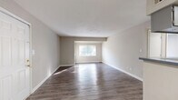 Located at 204 Chambers Cove Drive in Macon, Georgia, this two-bedroom, two-bathroom residence offers a practical and comfortable single-floor layout. The open living and dining area makes a strong first impression with its durable wood-look laminate flooring, neutral wall tones, and a large window that allows natural light to fill the space generously. The kitchen is efficiently designed with gray cabinetry, laminate countertops, a range, and matching wood-look flooring that ties the common areas together seamlessly. A hallway connects the living spaces to the private quarters, providing a clear separation between living and sleeping areas. The spacious primary bedroom features plush wall-to-wall carpeting and a window with blinds, offering a quiet retreat. The second bedroom is equally well-appointed with soft carpeting, two windows for added natural light, and a double-door closet for ample storage. Both bathrooms are outfitted with tub-shower combinations and wood-look flooring, maintaining a consistent and clean aesthetic throughout. Neutral paint tones and white trim work unify the overall look of the residence, creating a calm, move-in-ready atmosphere throughout.
