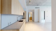 Located in Miami's vibrant Wynwood neighborhood, this modern one-bedroom, one-bathroom unit offers a thoughtfully designed open-concept layout with clean, contemporary finishes throughout. Large-format porcelain tile flooring runs seamlessly across the living and kitchen areas, complementing the bright, white walls and exposed concrete ceiling accents that give the space an urban, loft-inspired character.

The kitchen is a standout feature, outfitted with sleek light wood cabinetry extending from floor to ceiling, a gray quartz countertop, an undermount sink with a modern faucet, a built-in induction cooktop, a stainless steel oven, and an integrated microwave — delivering a fully equipped and stylish culinary space.

The bedroom is a comfortable, well-proportioned retreat with tile flooring, clean white walls, and access to a dedicated closet. The bathroom features warm wood cabinetry, a gray countertop with an undermount sink, a full-width mirror, and a glass-enclosed walk-in shower, all finished with light tile for a clean, modern aesthetic.

A highlight of the unit is the expansive private outdoor terrace, finished with large white tiles and enclosed by low white walls, offering open views of the surrounding Wynwood skyline — an exceptional outdoor amenity perfect for Miami's year-round warm climate.