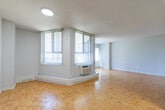 Located at 1547 Mississauga Valley Blvd in Mississauga, Ontario, this single-floor unit offers three bedrooms and two bathrooms within a well-organized and practical layout. Warm parquet hardwood flooring runs throughout the living areas and bedrooms, adding a classic character to the space. The living room is generously proportioned, benefiting from dual windows dressed with vertical blinds that invite natural light and offer views of surrounding greenery. A wall-mounted air conditioning unit provides climate control comfort. Each of the three bedrooms features the same warm parquet flooring and is finished with neutral-toned walls, offering a clean and versatile canvas. The primary bedroom provides a comfortable footprint with closet access and natural light. The secondary bedrooms are cozy yet functional, suitable for various uses. Both bathrooms are finished in clean white, with one featuring a full tiled surround bathtub and shower combination with chrome fixtures, maintaining a bright and tidy aesthetic. A connecting hallway ties the rooms together efficiently. The overall ambiance is clean, neutral, and move-in ready, with consistent finishes throughout that create a cohesive and practical living environment.